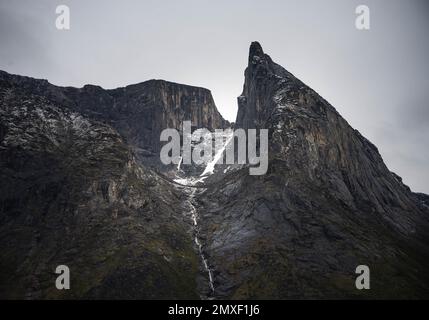 Southwest face of Mt. Thor, highest vertical cliff on Earth, on a cloudy September day. Hiking in wild, remote arctic valley of Akshayuk Pass, Baffin Stock Photo