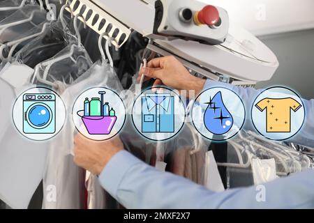 Different icons and male worker taking clothes from garment conveyor at dry-cleaner's, closeup Stock Photo