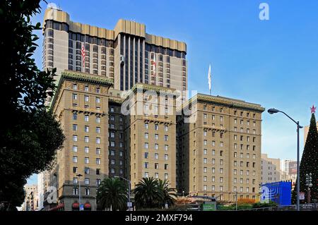 Westin St. Francis Hotel at Union Square in San Francisco, with festive menorah and Christmas decorations, framed by blue skies and modern buildings. Stock Photo