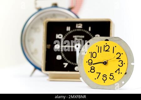 three retro alarm clocks on isolated background. Stock Photo