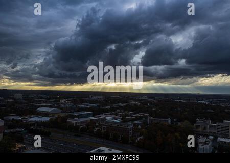 Sunbeams shine through dark, ominous storm clouds over midtown Atlanta Stock Photo