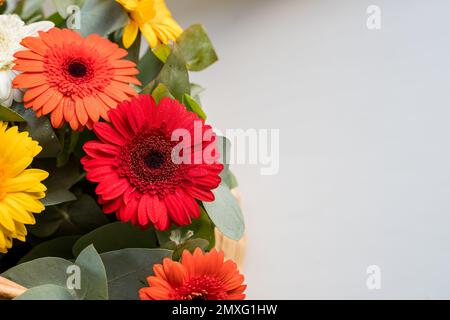 Gerber Daisy's Sitting a a beautiful basket at the local farmers market.Bouquet with gentle yellow, red, orange daisies and pink flowers. celebration Stock Photo