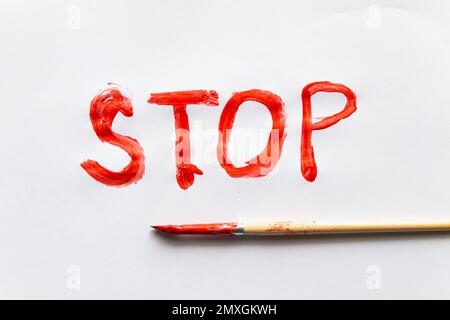 inscription stop written in red paint on a white background Stock Photo