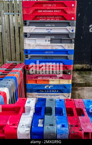 Plastic fish boxes, crates from many different ports in Europe stored on quayside. Colourful abstract, background, concept. UK fishing industry. Stock Photo