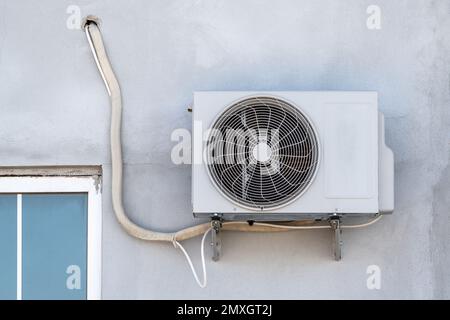 Split air conditioner outdoor unit hung outside the building Stock Photo