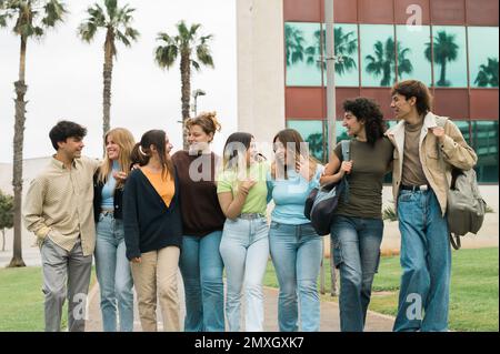 Positive diverse students walking together in campus and talking Stock Photo