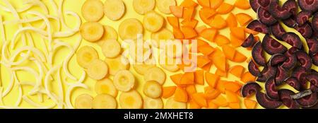 Pieces of raw color carrots on yellow background, flat lay Stock Photo