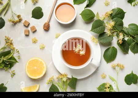 Flat lay composition with tasty tea and linden blossom on light grey marble table Stock Photo