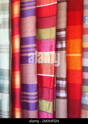 Colorful swatches of silk fabric with African patterns hanging on a street market stall in Medina souk, Marrakesh, Morocco, North Africa Stock Photo