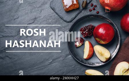 Honey, apples and pomegranates on black table, flat lay. Rosh Hashanah holiday Stock Photo