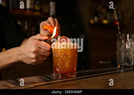 Bartender preparing fresh alcoholic cocktail at bar counter, closeup Stock Photo