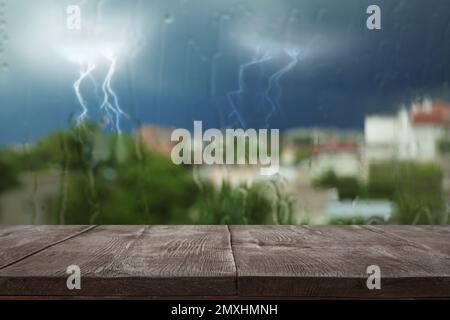 Wooden table near window on rainy day Stock Photo