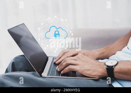 Cyber security concept. Man using laptop, closeup. Cloud with padlock illustration over keyboard Stock Photo