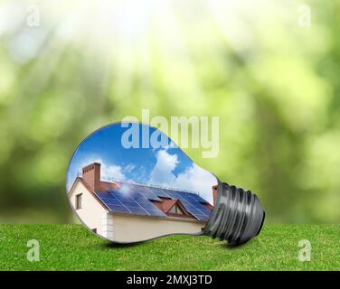 Alternative energy source. Light bulb with solar panels outdoors Stock Photo