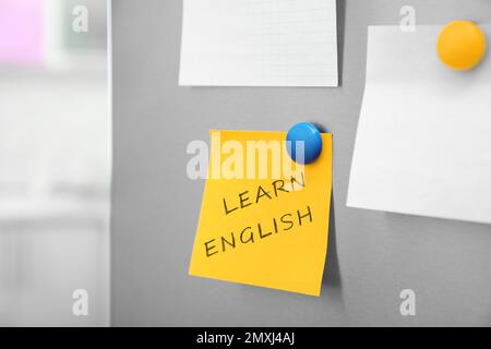 Note with text Learn English on refrigerator door in kitchen Stock Photo