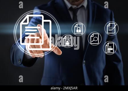 Man pointing at document icon on virtual screen, closeup Stock Photo