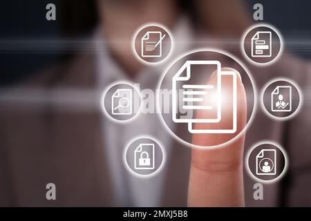 Woman pointing at document icon on virtual screen, closeup Stock Photo