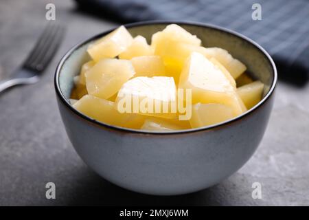 Tasty canned pineapple in bowl on grey table, closeup Stock Photo