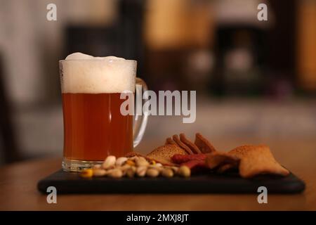 Two tall elegant pint glasses of cold wheat beer with a frothy head on a  wooden bar table conceptual of Oktoberfest Stock Photo - Alamy