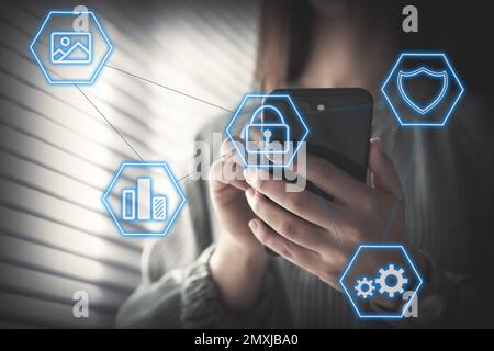 Information security. Young woman using smartphone indoors, closeup Stock Photo