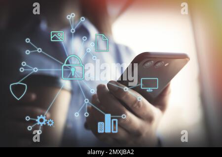 Information security. Young woman using smartphone indoors, closeup Stock Photo