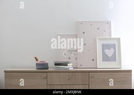 Chest of drawers with paintings in stylish living room Stock Photo