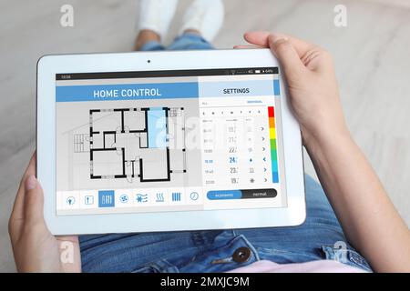 Woman using energy efficiency home control system on tablet, closeup Stock Photo