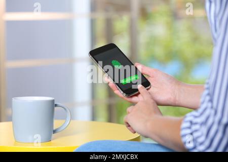 Woman scanning fingerprint on smartphone outdoors, closeup. Digital identity Stock Photo