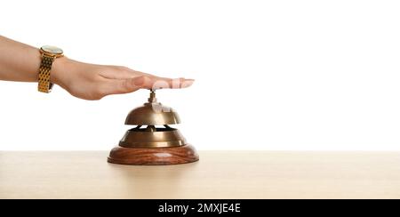 Woman ringing hotel service bell at wooden table Stock Photo