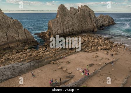 people in swimsuits sunbathing and bathing in Arnía beach is located in the municipality of Piélagos, Liencres, Cantabria, Spain, Europe Stock Photo