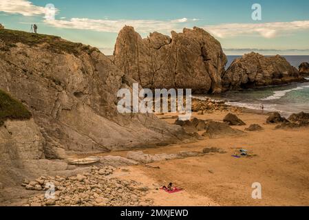 people in swimsuits sunbathing and bathing in Arnía beach is located in the municipality of Piélagos, Liencres, Cantabria, Spain, Europe Stock Photo