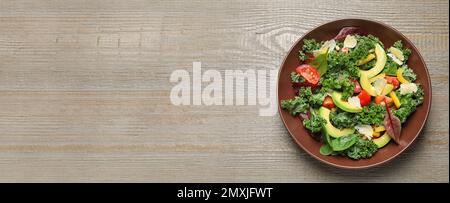Tasty fresh avocado salad and space for text on wooden table, top view. Banner design Stock Photo