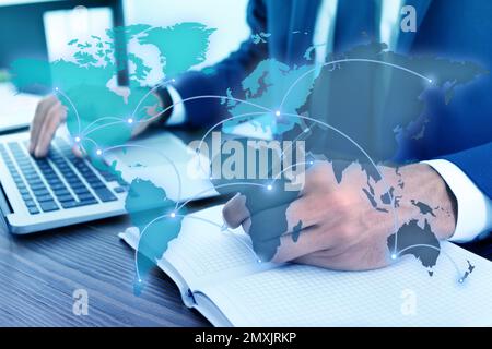 Wholesale and logistics concept. Man using laptop in office, world map illustration on foreground Stock Photo