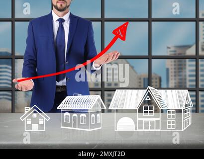 Real estate agent demonstrating prices at housing market. Man with graph illustration, closeup Stock Photo