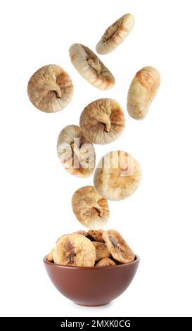 Dried fig fruits falling into bowl on white background Stock Photo