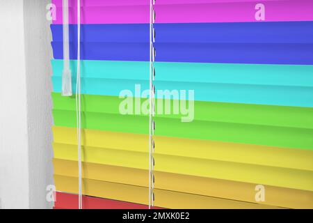 Window with closed multicolor blinds, closeup view Stock Photo