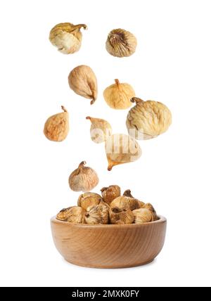 Dried fig fruits falling into bowl on white background Stock Photo