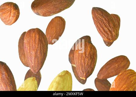 Falling almond isolated on a white background, selective focus. Almond nuts levitate on a white background. Freeze motion of flying whole almonds. Stu Stock Photo