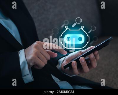 Chat GPT and AI search (searching by artificial intelligence technology) concepts. Chatbot, smart robot icon appear on smart mobile phone while busine Stock Photo