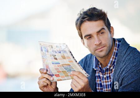 Thats something to think about. a man looking thoughtful while holding the newspaper. Stock Photo