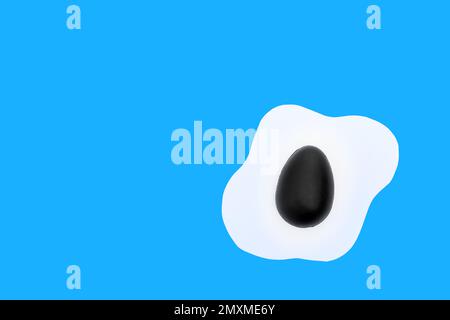 Creative layout made of scrambled eggs with painted black half Easter eggs on a blue background. Minimal Spring holidays concept. Stock Photo