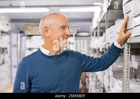 Taking care of your order. a man searching shelves in a distribution warehouse. Stock Photo