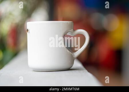 Love in Every Sip: A Close-Up of a White Mug with Love Handle Stock Photo
