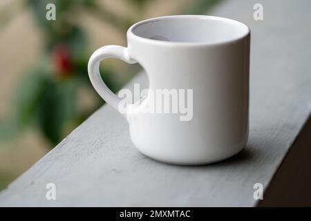 Love in Every Sip: A Close-Up of a White Mug with Love Handle Stock Photo