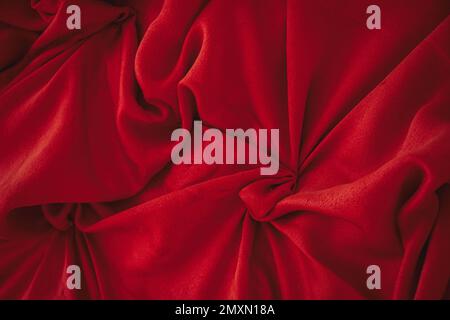 red wavy silky crumpled fabric as background close up Stock Photo