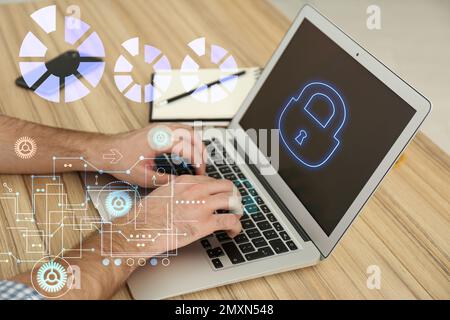 Cyber attack protection. Man using modern laptop with lock illustration at table, closeup Stock Photo