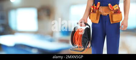 Closeup view of electrician with tools indoors, space for text. Banner design Stock Photo