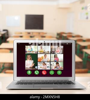 Distance education during quarantine and lockdown due to Covid-19 pandemic. Modern laptop displaying online school lesson in classroom Stock Photo