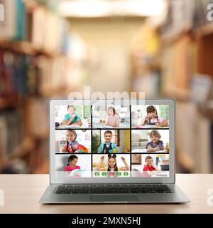 Distance education during quarantine and lockdown due to Covid-19 pandemic. Modern laptop with online classroom on screen in library Stock Photo