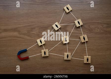 Attracting human icon With Horseshoe Magnet On wooden Background. Stock Photo